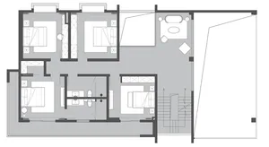 A black and white architectural floor plan depicting a residential layout with multiple bedrooms and a common area.