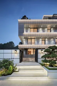 A modern residential house featuring a metal-clad facade at dusk.