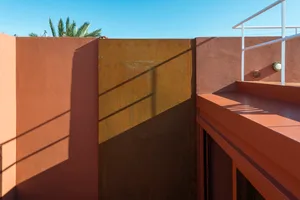 Metal panel with rust stains on a red wall