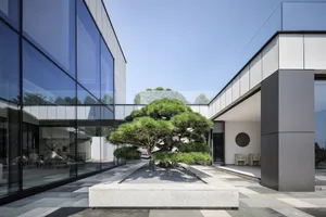 Modern interior design featuring glass walls and concrete floor.