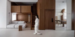 A modern living room with wooden paneling, a white sectional sofa, and a minimalist aesthetic.