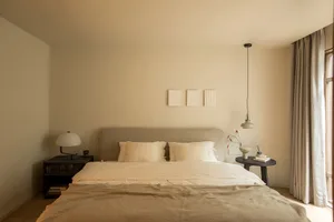 A minimalist bedroom with neutral tones and simple decor.
