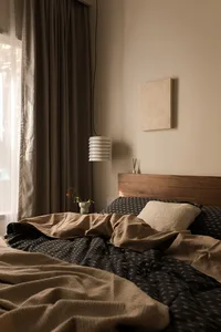 A modern minimalist bedroom featuring soft textiles and neutral color palette.