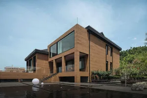 Modern residential home with concrete external walls and large glass windows.