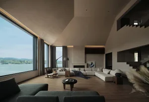 A modern living room with a large sectional sofa, a fireplace, and large windows overlooking a lake.
