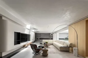 A modern residential living room featuring concrete, marble, and wooden elements.