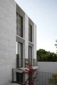 A modern residential building with concrete exterior walls and large windows.