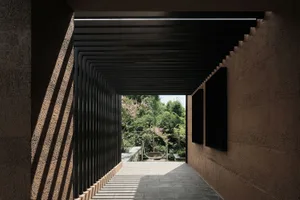 Concrete and steel corridor with garden view, modern architectural design.