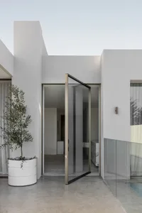 Modern minimalist exterior with glass doors and clean lines.