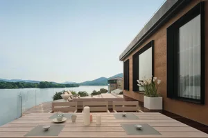 Modern residential terrace featuring wood, concrete, and glass materials with a scenic lake view.