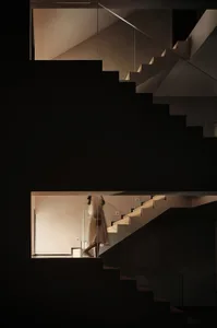 A modern interior featuring a glass staircase with minimalist design