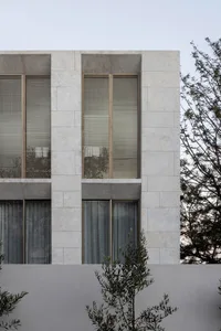 Modern building with stone exterior and large windows.