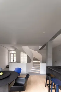 現代室內設計，展示一座內建照明的混凝土螺旋樓梯。