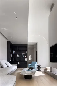 Modern living room with concrete walls, a minimalist design, and a mix of textures and colors.