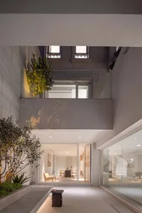 Modern minimalist living room with large glass window, white walls, and simple furniture.