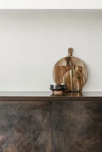A modern kitchen with a wooden board on a dark, textured countertop.