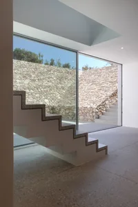A modern interior space featuring a stone staircase with concrete treads.