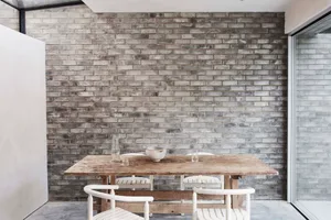 Industrial dining room featuring wooden furniture and concrete walls