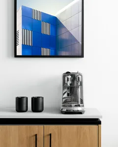 A minimalist coffee station featuring glass and stainless steel materials.