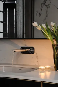 Modern bathroom interior featuring a sink with a wall-mounted faucet and white tulips in a vase, with ambient lighting and ma