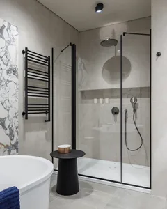 A modern bathroom featuring marble tiles and fixtures.