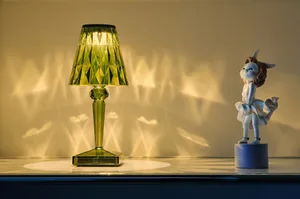 A modern decorative lamp with a glass shade casting intricate patterns on the wall.