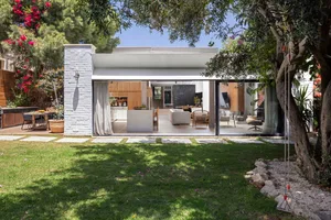 Modern house exterior with glass walls and a white facade.