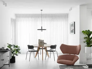 Modern living and dining room featuring furniture made from wood, cotton canvas upholstery, metal accents, and minimalistic d