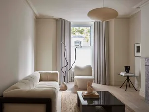 A modern living room featuring a minimalist interior with a bitonish sofa, a cozy armchair, and a sleek side table.