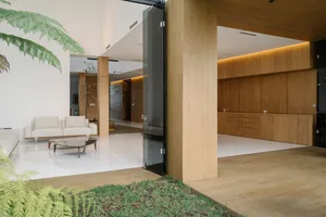 Modern interior design featuring a living room with wooden furniture, white tiles, and plant life.