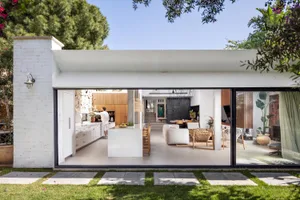 A modern living, dining, and kitchen space with open layout and white tile floor.