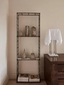 A minimalist metal shelving unit displaying abstract sculptures.