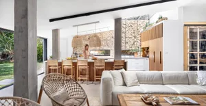 A modern living room and kitchen with concrete and wooden elements