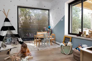 A modern, minimalist children's room with a teepee, wooden furniture, and playful decor.