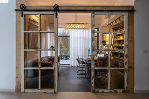 A home office featuring industrial design elements with glass and wood sliding doors.