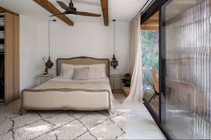 Modern minimalist bedroom with wooden beams, white curtains, and a comfortable bed.