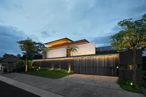 Modern residential home exterior with cladding materials and illuminated features.