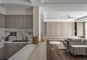 Modern, minimalist residential kitchen featuring light wood cabinets and sleek, clean lines.