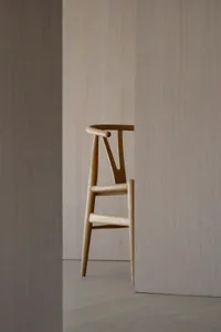 Modern wooden bar chair against neutral background