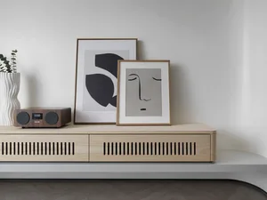 A modern wooden cabinet with a sleek design, featuring two drawers and a radio receiver on top.