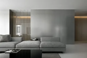 A modern industrial living room featuring grey fabric furniture, minimalist decor, and a sleek, glossy floor.