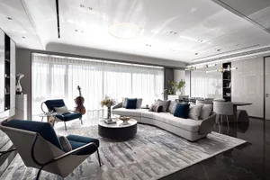 Contemporary living room with modern interior design elements, featuring a curved sofa, dark armchairs, and large windows.