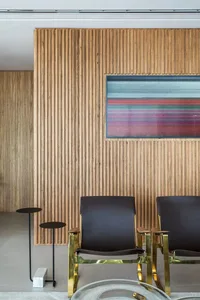 Modern office waiting area featuring a wooden accent wall and metallic chairs.