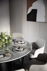 A sleek, modern dining room with a marble table and contemporary chairs, featuring white and gray decor.
