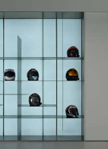 Modern interior design featuring glass display cases showcasing various motorcycle helmets.