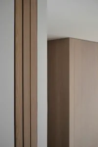 Modern interior design featuring a minimalist wall panel made of wood.
