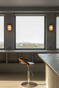 A modern kitchen with a concrete countertop and minimalist design.