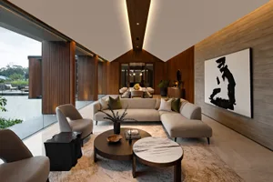 A modern living room with a wooden floor, marble coffee tables, and glass accents.