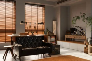 A modern industrial living room featuring wooden blinds and a leather sofa, with a focus on the minimalist design and the use