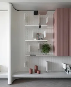 Modern white wooden bookshelf with green plant and decorative items.